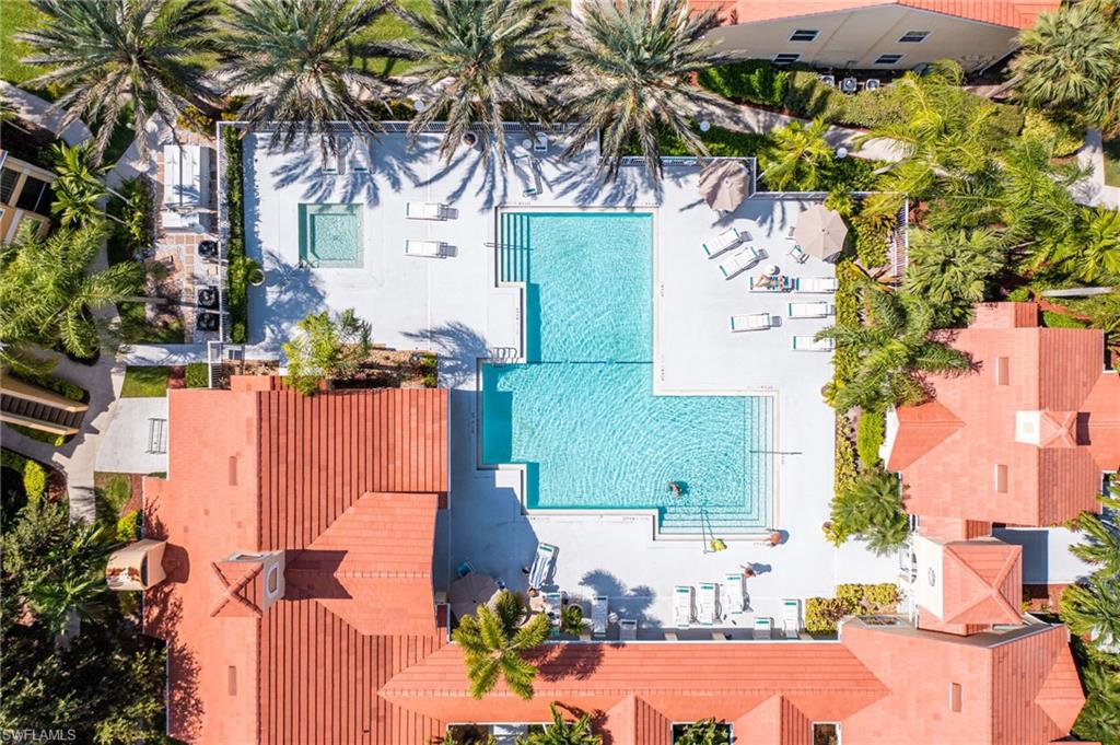 L-shaped swimming pool with an integrated spa, surrounded by a spacious sun deck