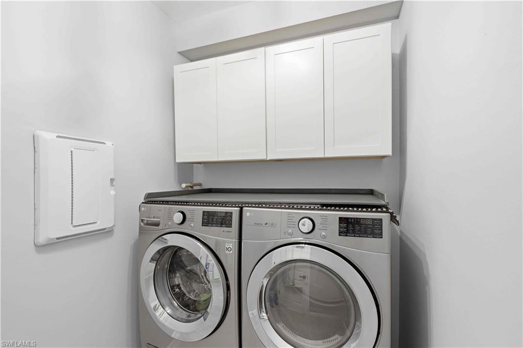 Laundry area featuring white shaker-style cabinetry, a built-in countertop above appliances, and light neutral wall finishes. Washer and Dryer, do not convey.