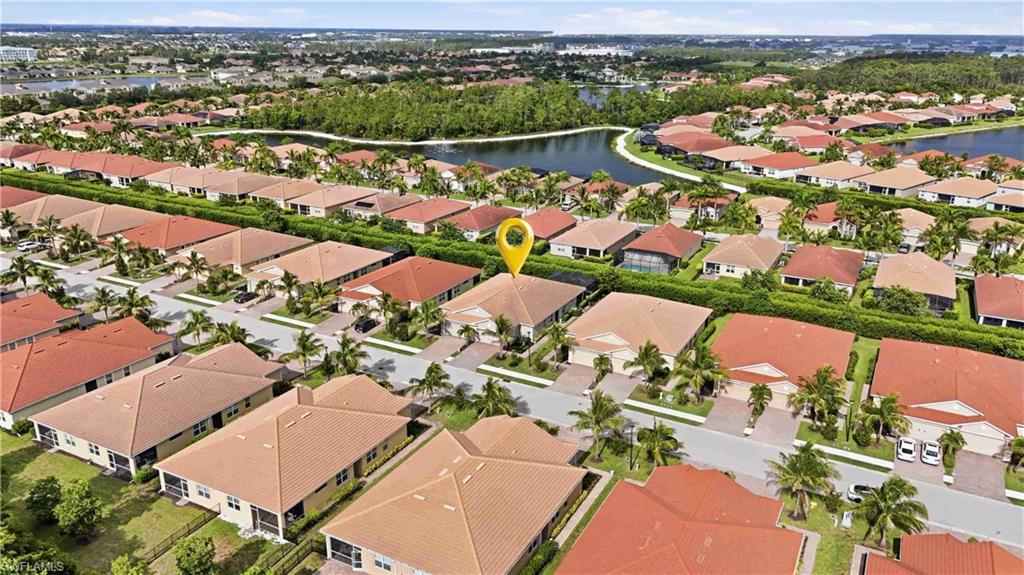 Aerial perspective showcasing a residential community with uniform terracotta-tiled roofs, individual driveways, and manicured landscaping
