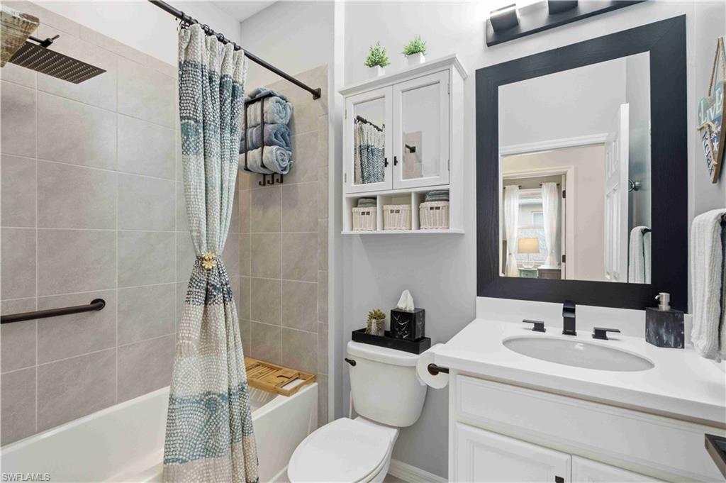 Bathroom featuring a white vanity with a rectangular sink and matte black faucet, a framed mirror, and a white medicine cabinet with open shelving