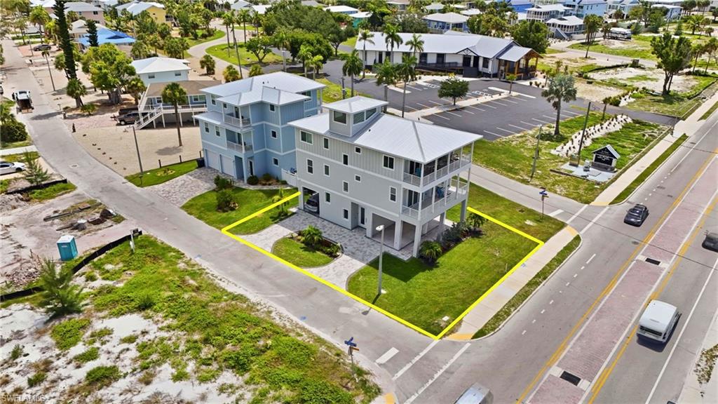 Multi-level property featuring light blue and gray siding, multiple balconies, and a metal roof - Virtually Edited Image