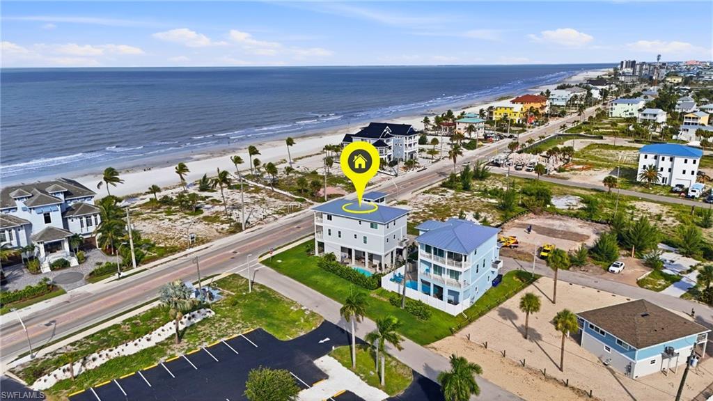 Three-story coastal residence featuring a flat roof and ground-level open-air space - Virtually Edited Image