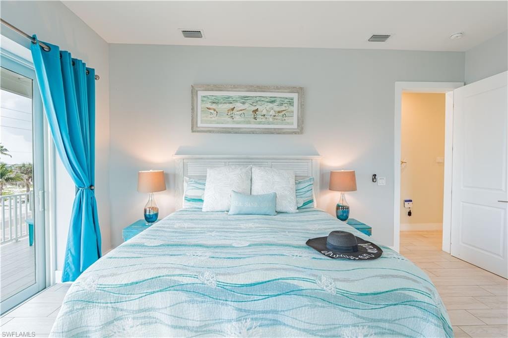 Bedroom featuring a white paneled headboard and light-toned flooring - Virtually Edited Image