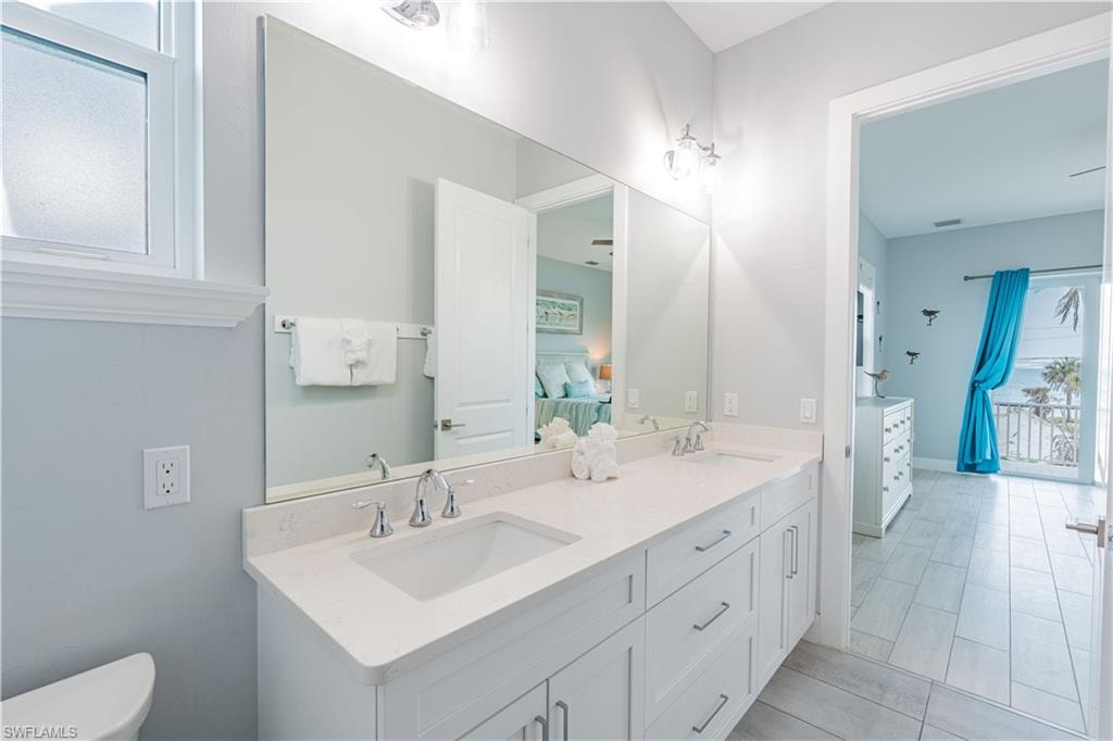 Dual vanity featuring undermount sinks, chrome fixtures, and a light-toned countertop - Virtually Edited Image