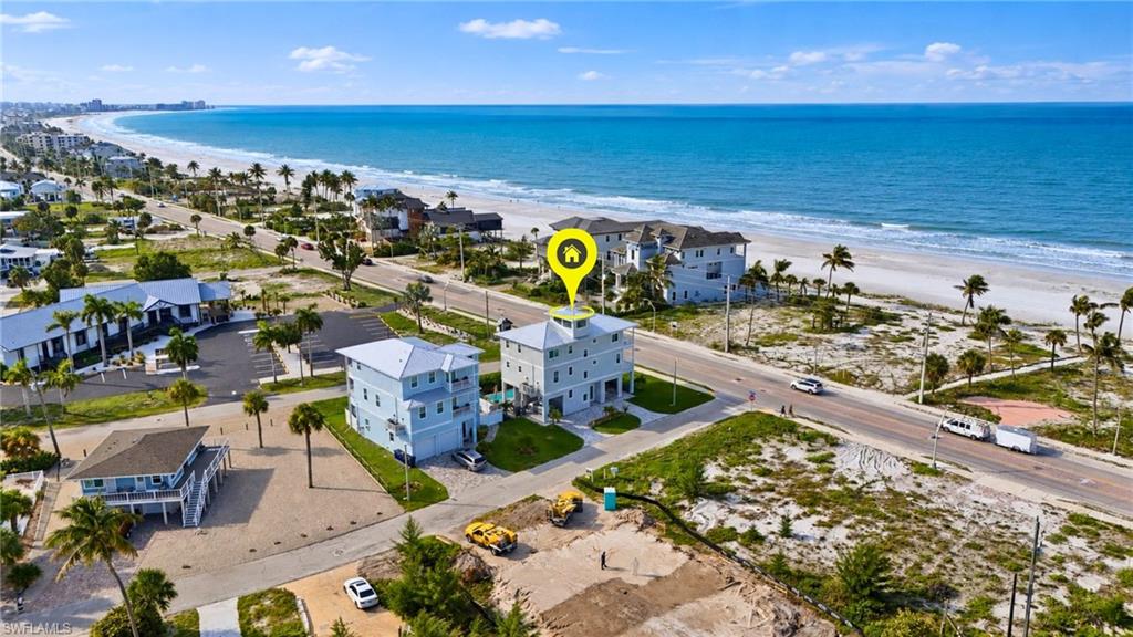 Coastal property featuring a multi-story light blue exterior and multiple balconies - Virtually Edited Image
