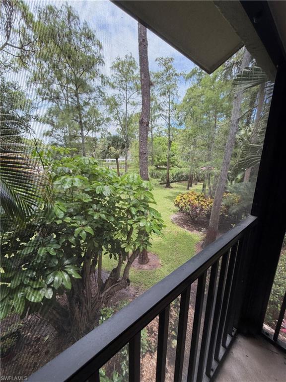 Screened balcony overlooking a landscaped green space with mature trees and established plantings