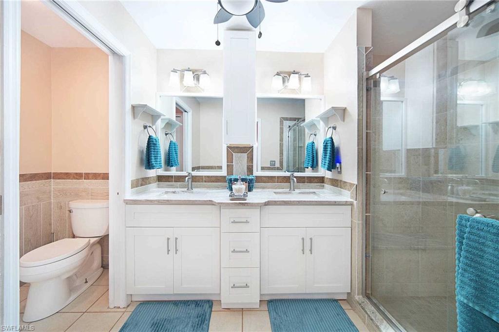 The primary attached bathroom has a dual sink vanity and walk-in shower