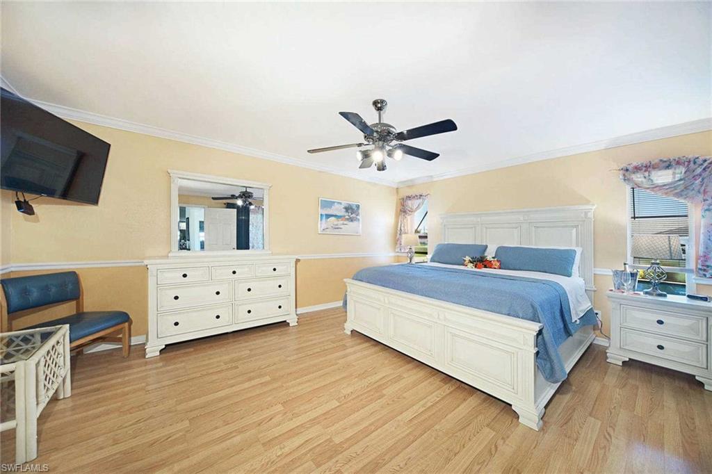 The spacious primary bedroom offers a king-size bed & flat-screen TV
