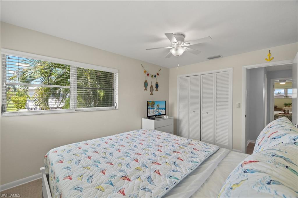 Bedroom with ceiling fan, carpet floors, a closet, and multiple windows