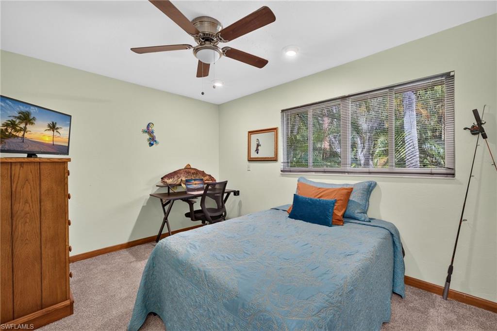 Bedroom with ceiling fan and window.