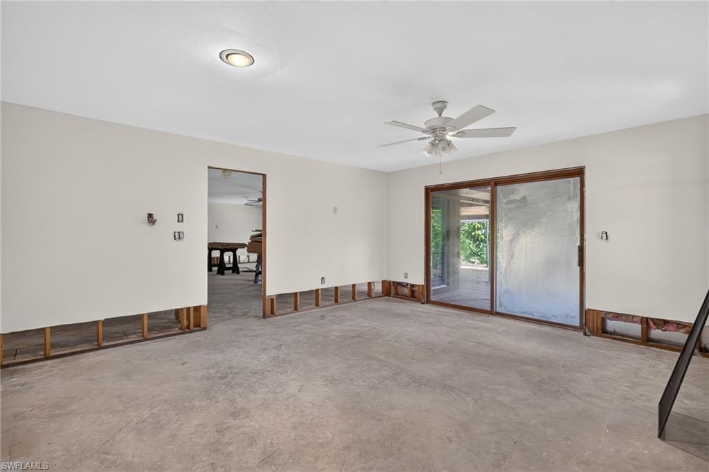 Spacious room with wood-finish flooring, featuring expansive glass sliding doors opening to an outdoor covered patio