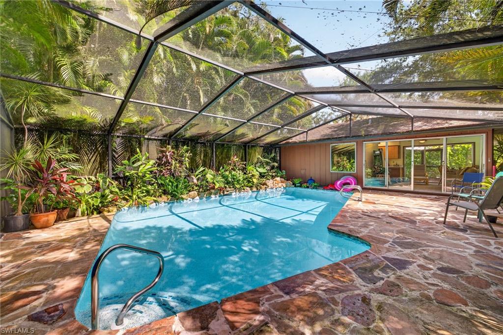 Pool surrounded by lush tropical foliage with adjacent casita