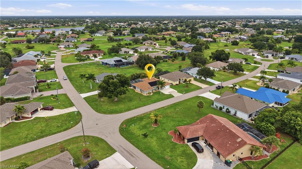 Aerial perspective showcasing a residential neighborhood with single-story homes and a prominent lake in the background