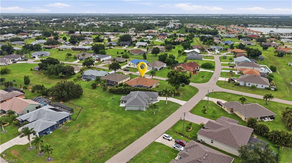 Aerial perspective showcasing a residential neighborhood with single-story homes and ample green spaces