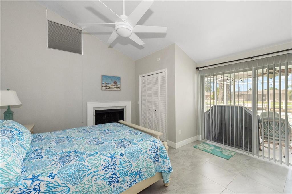 Bedroom featuring access to outside, high vaulted ceiling, a closet, a ceiling fan, and a fireplace