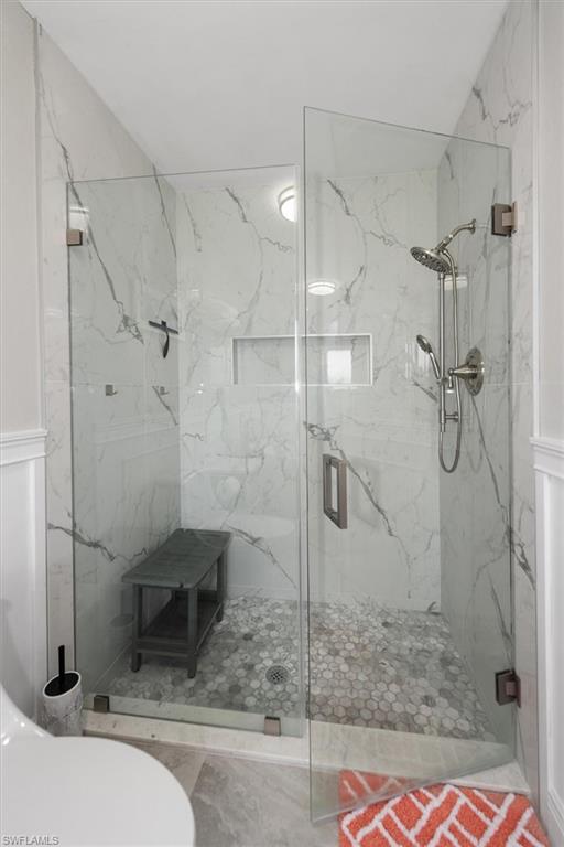 Bathroom with a marble finish shower and toilet
