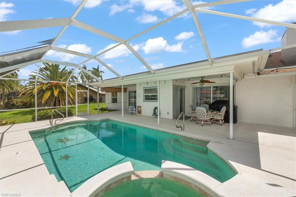 View of pool with a patio area, a pool with connected hot tub, a ceiling fan, and glass enclosure