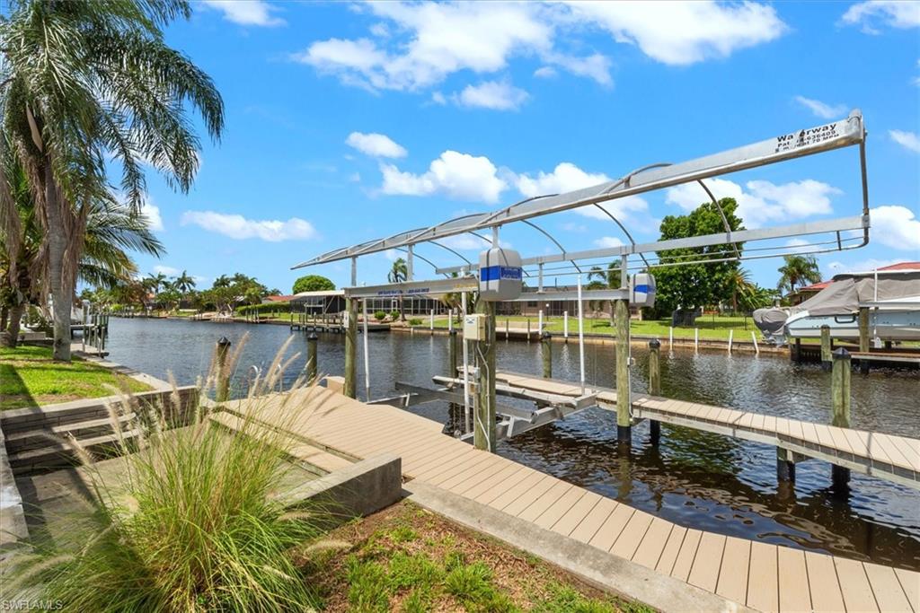 Dock area featuring boat lift and a water view