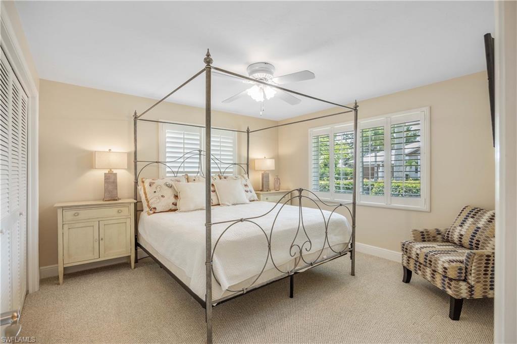 Bedroom featuring light carpet, ceiling fan, and a closet