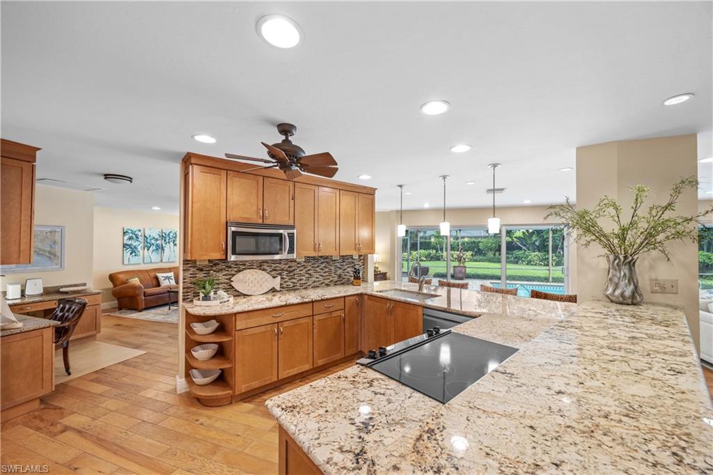 Kitchen featuring pendant lighting, tasteful backsplash, stainless steel appliances, sink, and ceiling fan