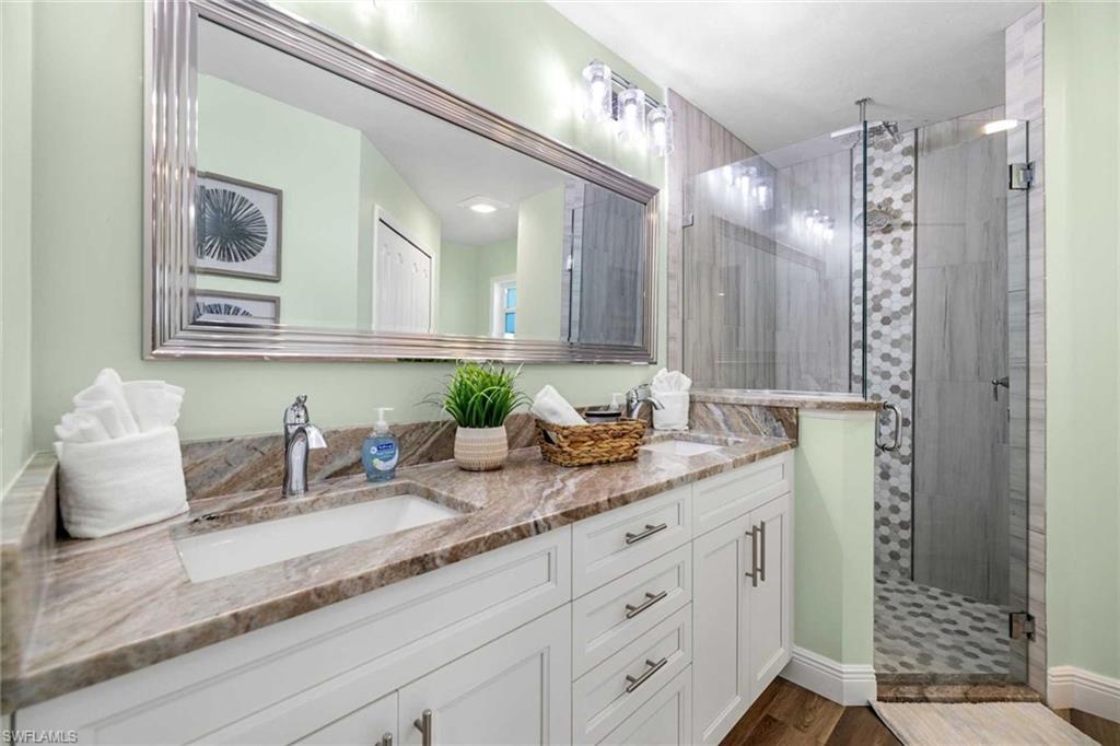 Primary bathroom has a double-sink vanity & walk-in shower