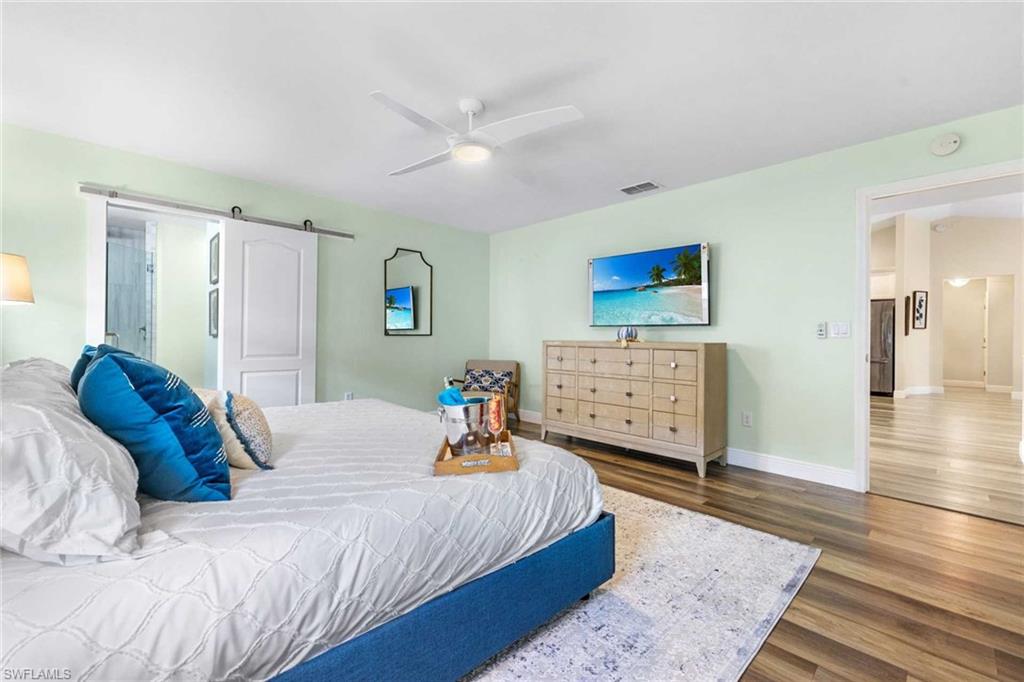 The primary bedroom is bright with a barn door entry to the bathroom