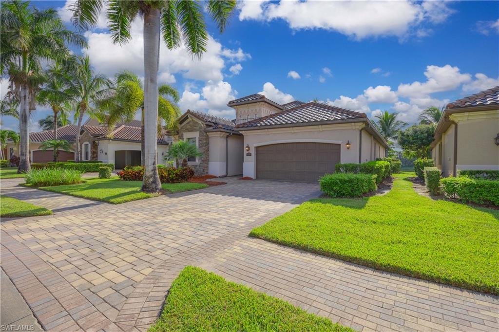Mediterranean / spanish-style house with a garage and a front yard