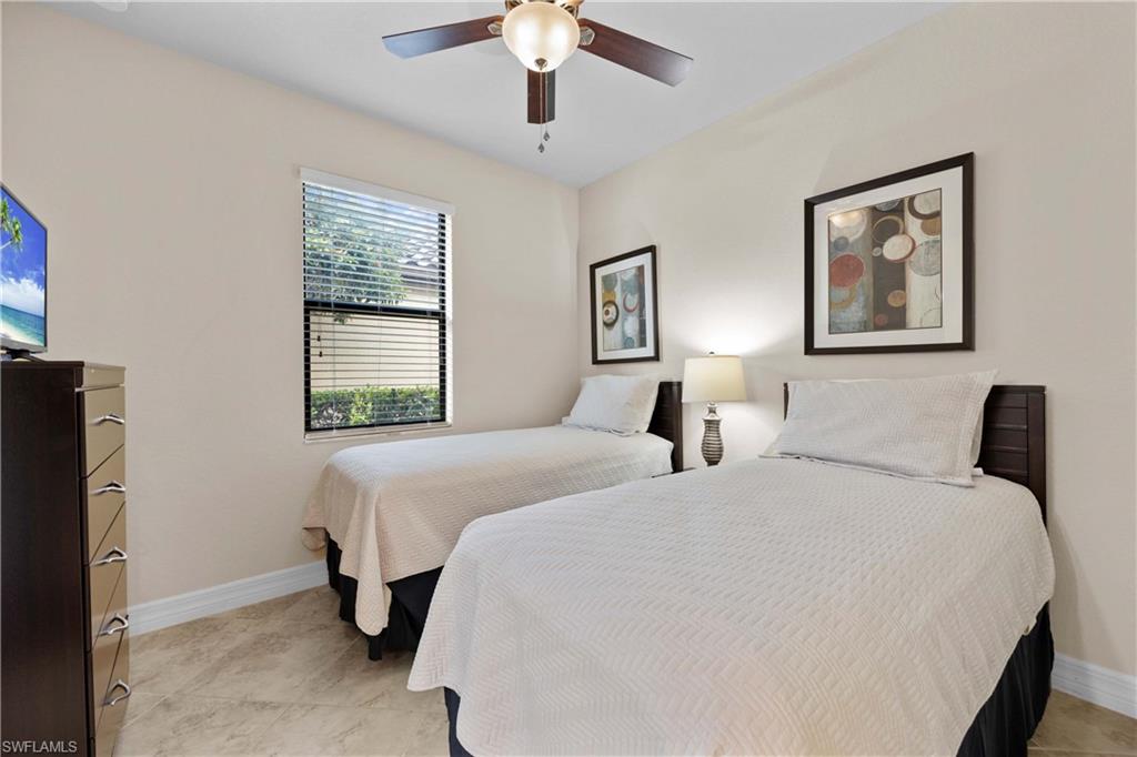 Bedroom with ceiling fan and light tile floors