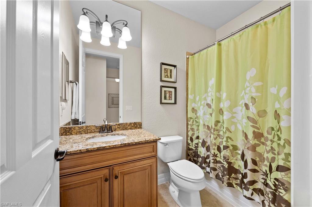 Bathroom with vanity, toilet, and tile floors