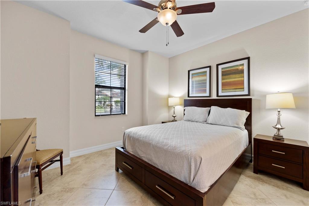 Tiled bedroom featuring ceiling fan