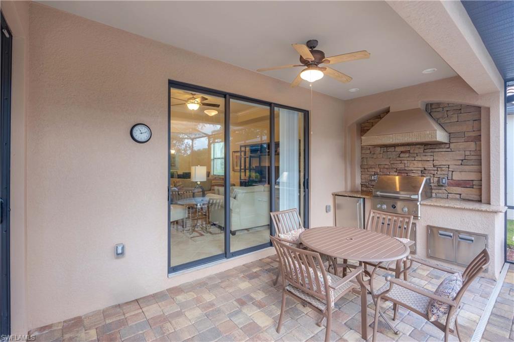 View of terrace with an outdoor kitchen, ceiling fan, and grilling area