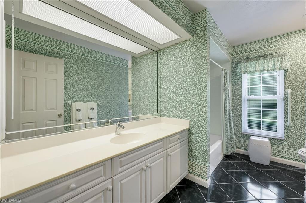 Guest bathroom features a large vanity and a shower/tub.