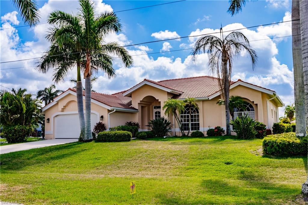Mediterranean / spanish-style home with a front yard and a garage