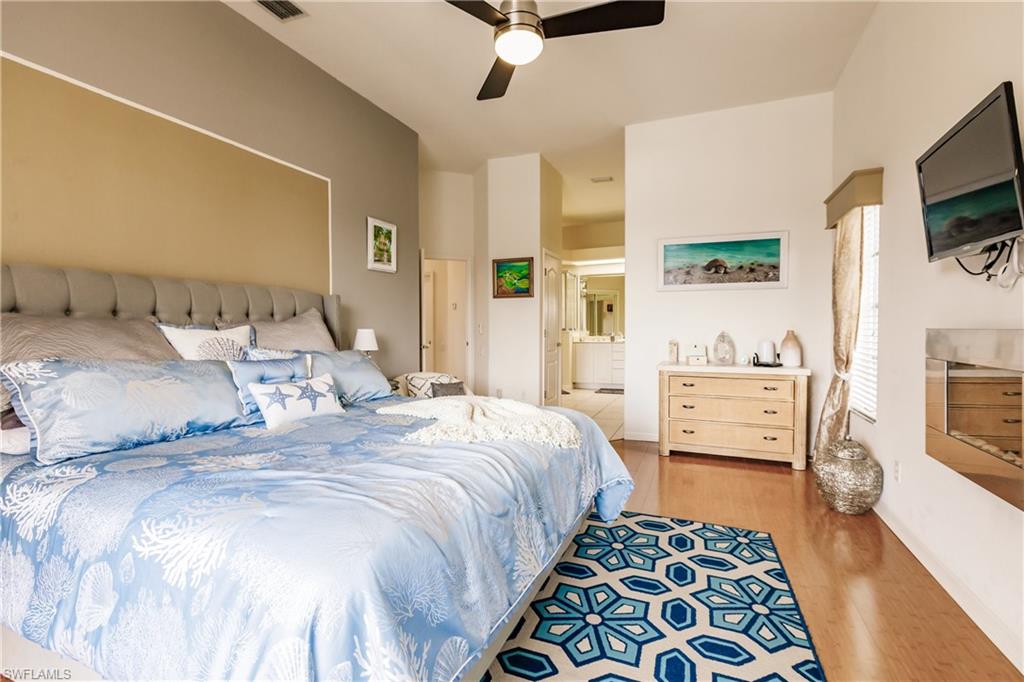Bedroom featuring light hardwood / wood-style flooring, ensuite bath, and ceiling fan