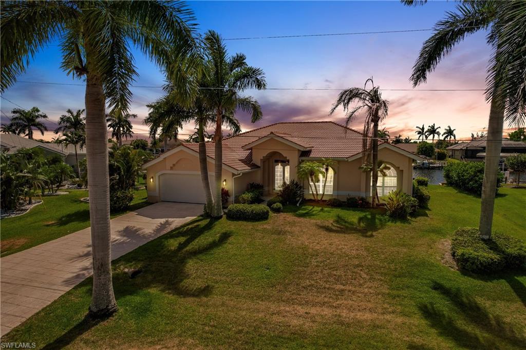 Mediterranean / spanish-style home with a garage and a yard