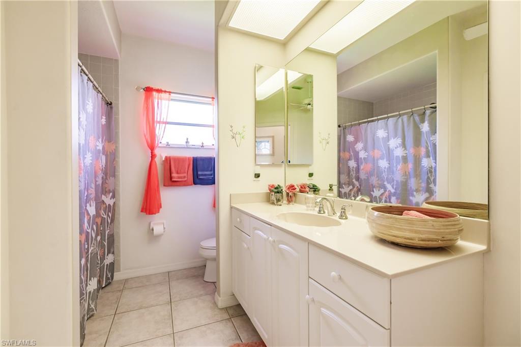 Bathroom featuring toilet, vanity, and tile patterned floors