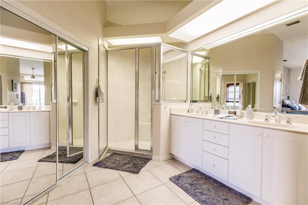 Bathroom featuring tile patterned floors, vanity, and a shower with shower door