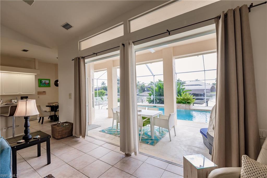 Doorway to outside featuring light tile patterned flooring and a healthy amount of sunlight