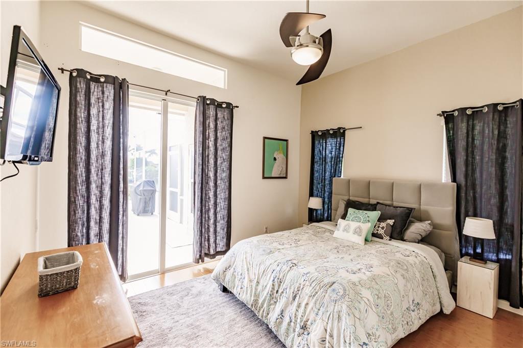 Bedroom with hardwood / wood-style floors, ceiling fan, and access to exterior