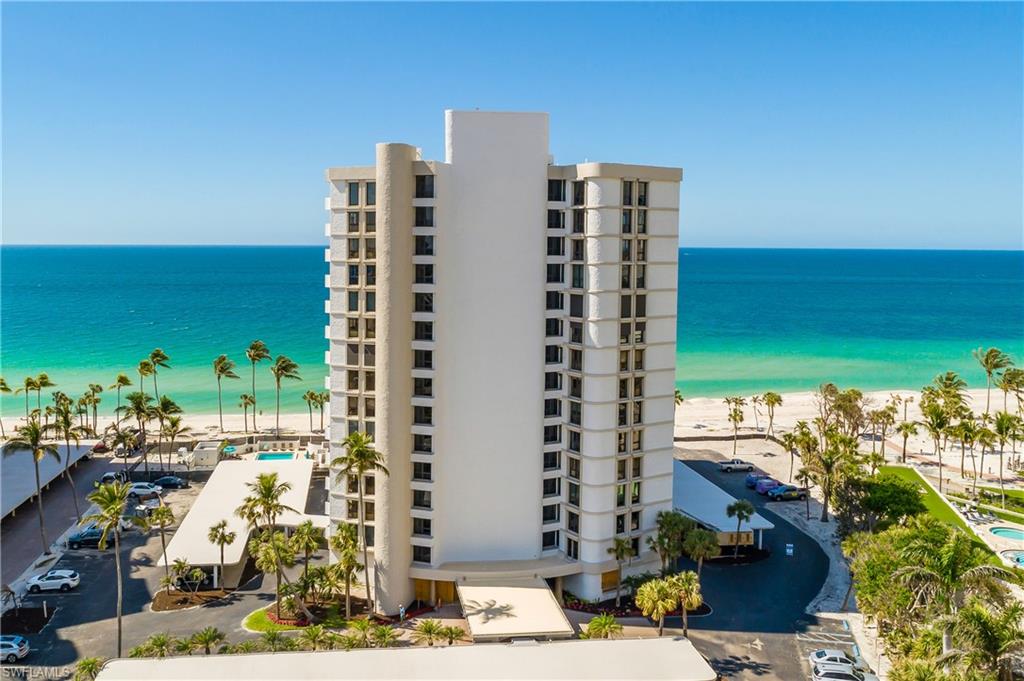 View of apartment building / complex with view of water and beach