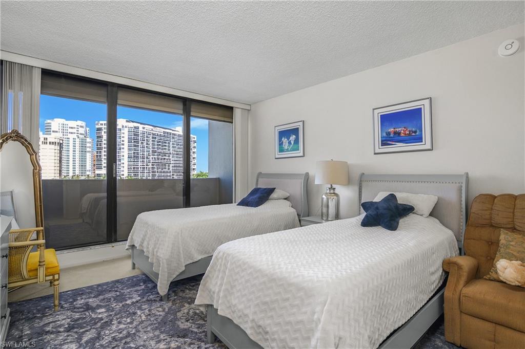 Second bedroom featuring a textured ceiling and floor to ceiling windows