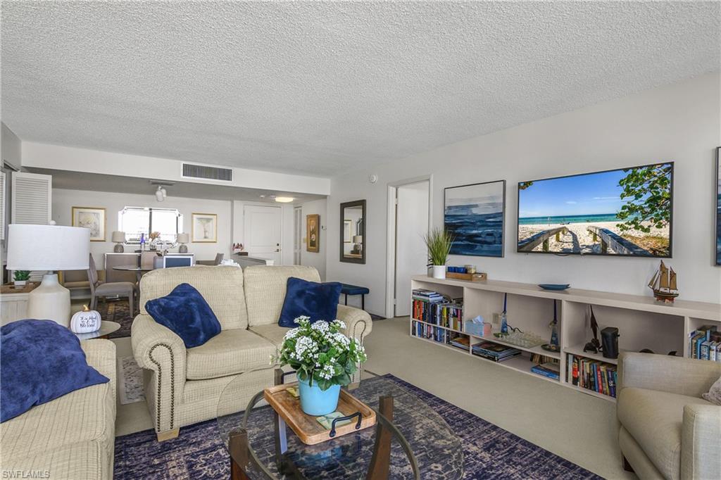 Carpeted living room featuring a textured ceiling