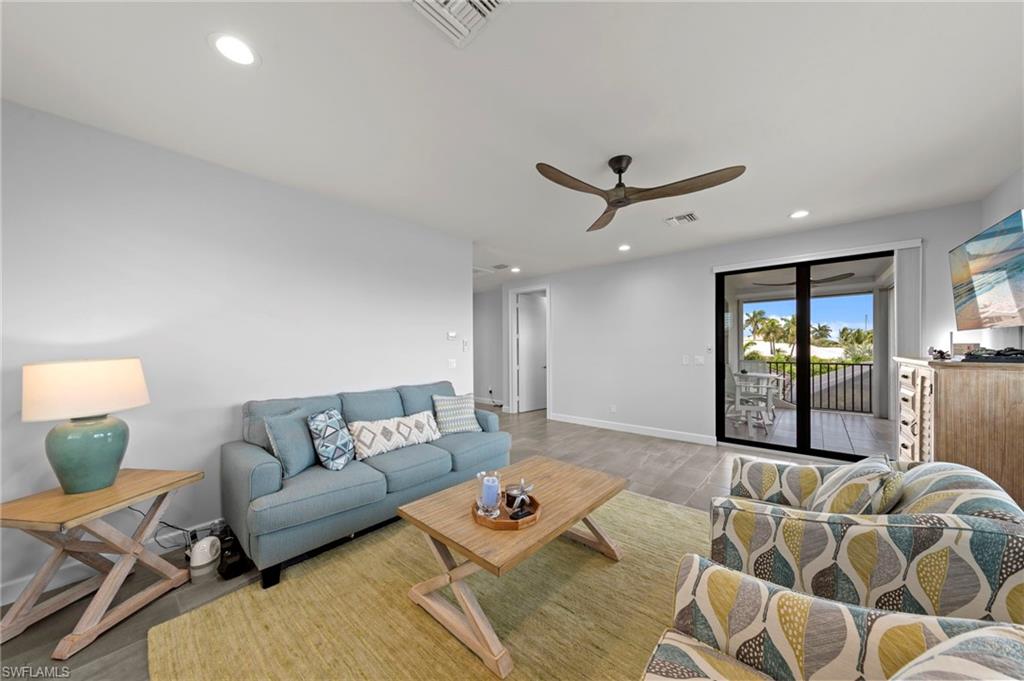 Spacious living area featuring light gray walls, recessed lighting, and a contemporary ceiling fan