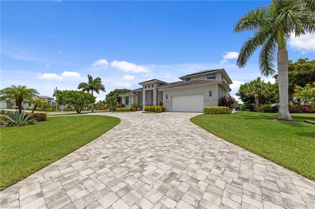 Circular paver driveway leading to a contemporary residence with a two-car garage