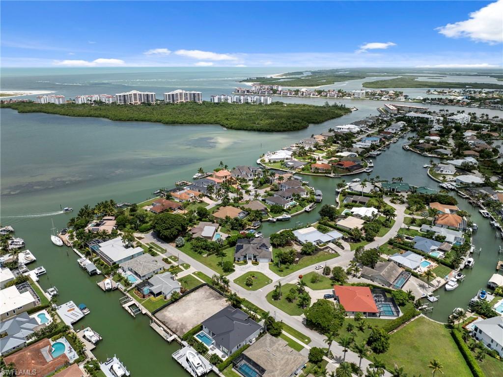Aerial perspective showcasing a coastal community with numerous waterfront properties, canals, and direct access to open water