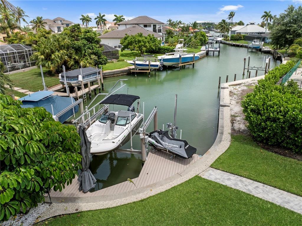 Waterfront property featuring a private boat lift, a composite decking dock, and direct canal access