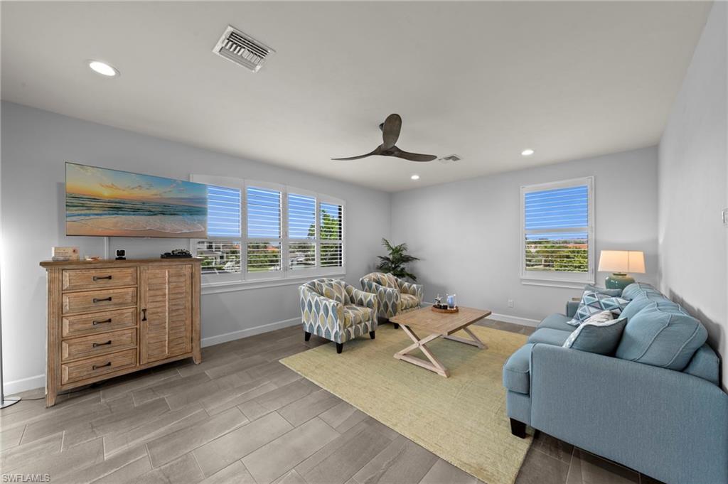 Spacious living area featuring wood-finish tile flooring and recessed lighting