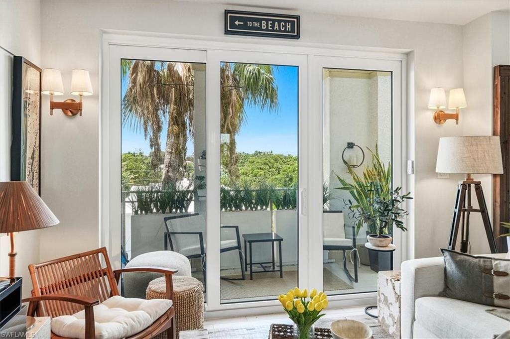 White sliding glass doors opening to an exterior balcony with black metal railings