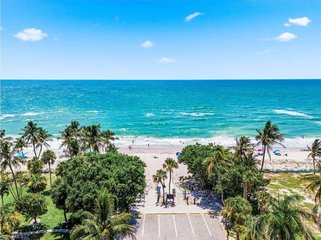 Expansive oceanfront vista featuring turquoise waters, sandy beach, and lush palm trees