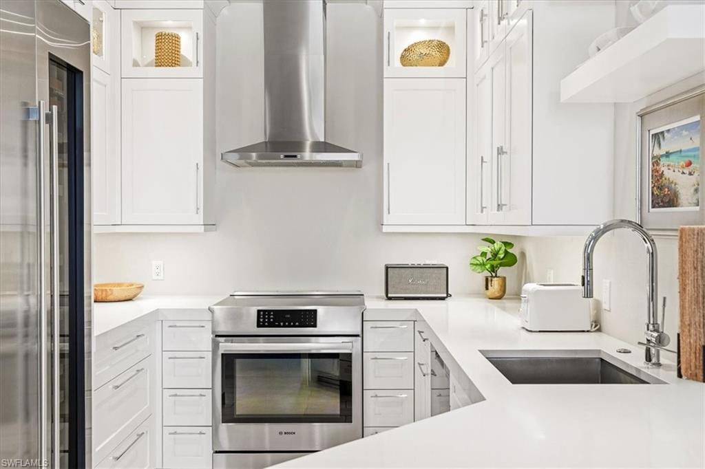 Modern kitchen featuring white cabinetry, stainless steel appliances, a stainless steel sink, and light-colored countertops